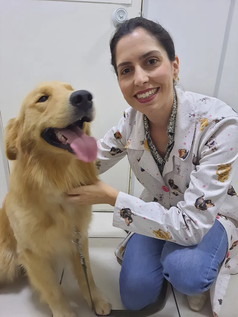 Dra. Alinne abraçada a um cão golden retriever